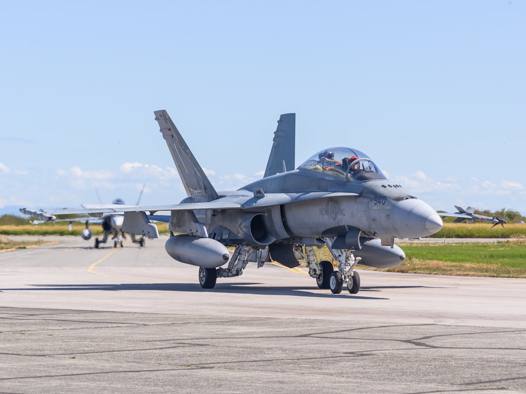 a fighter jet sitting on top of an airport tarmac, Two CF-18 Hornets taxi
