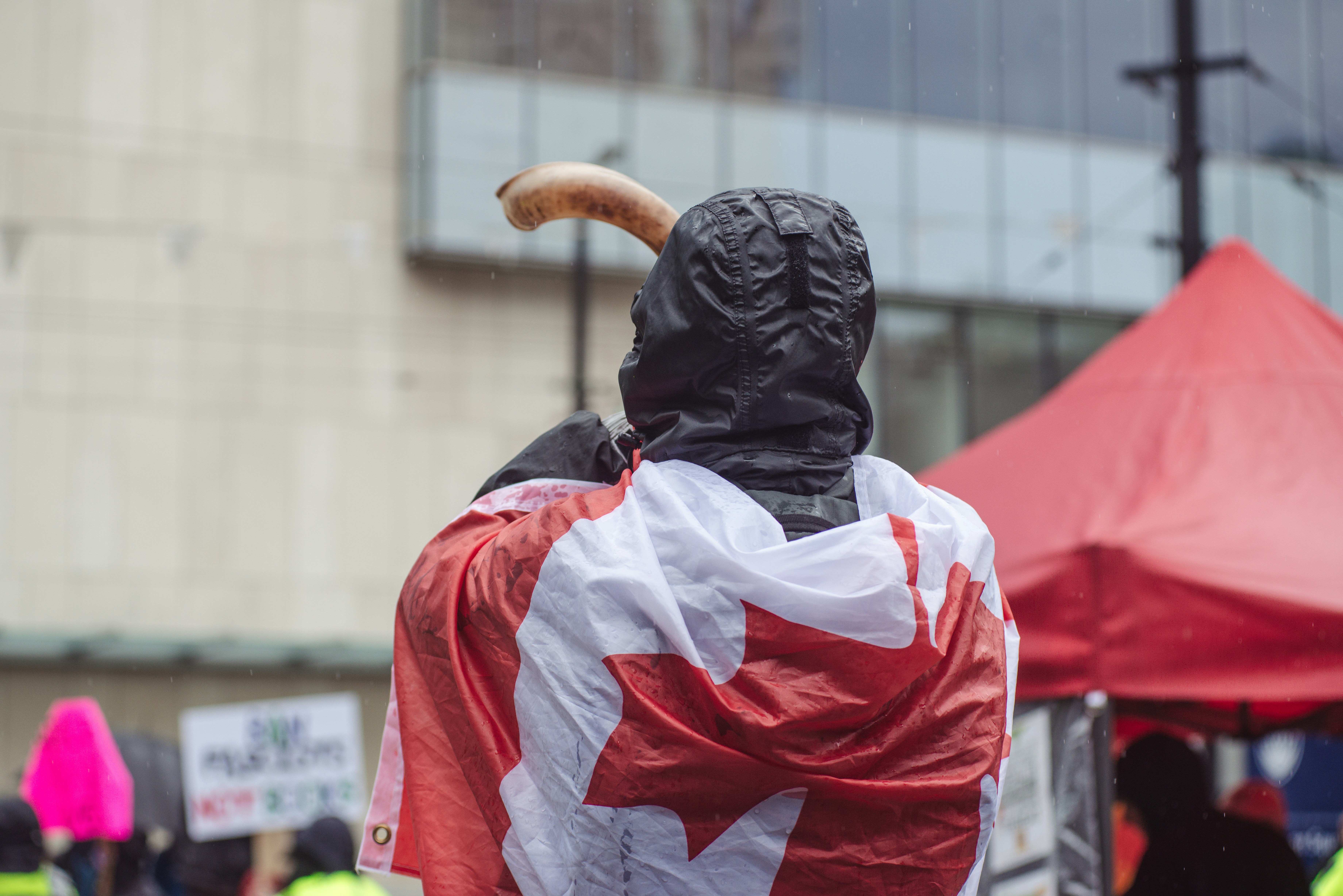 a statue of a man with a canadian flag draped around his shoulders, Protest in Downtown Vancouver on Sept 23, 2023.