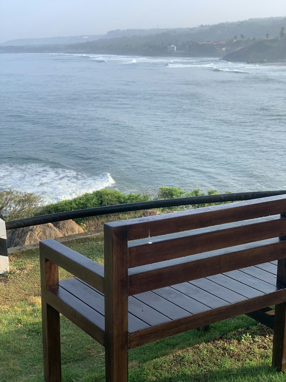 a wooden bench sitting on top of a lush green field