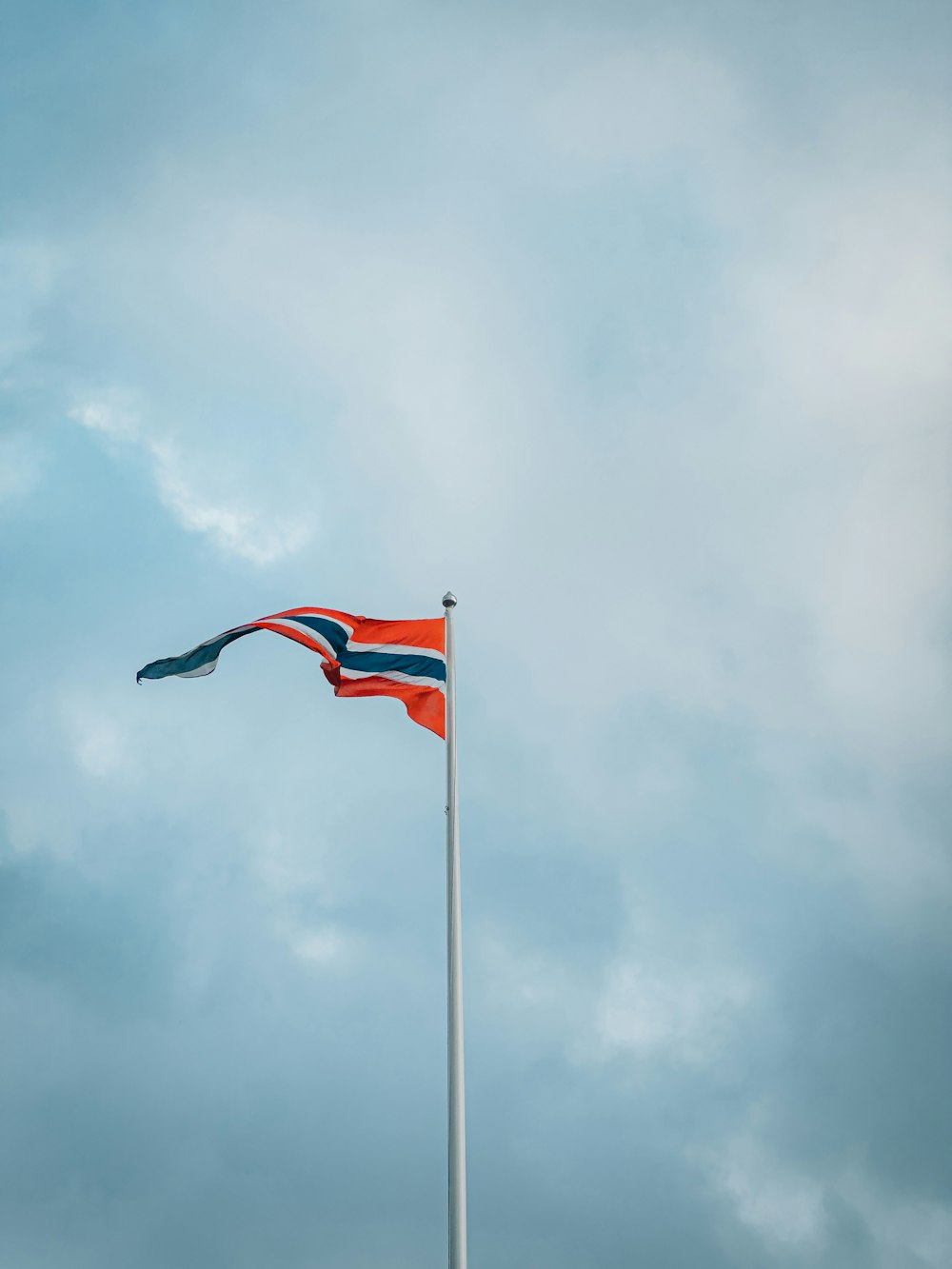 a flag flying in the wind on a cloudy day