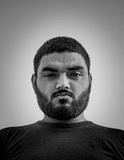 A minimalist black and white portrait of Alex El Pelón reflecting calm determination.