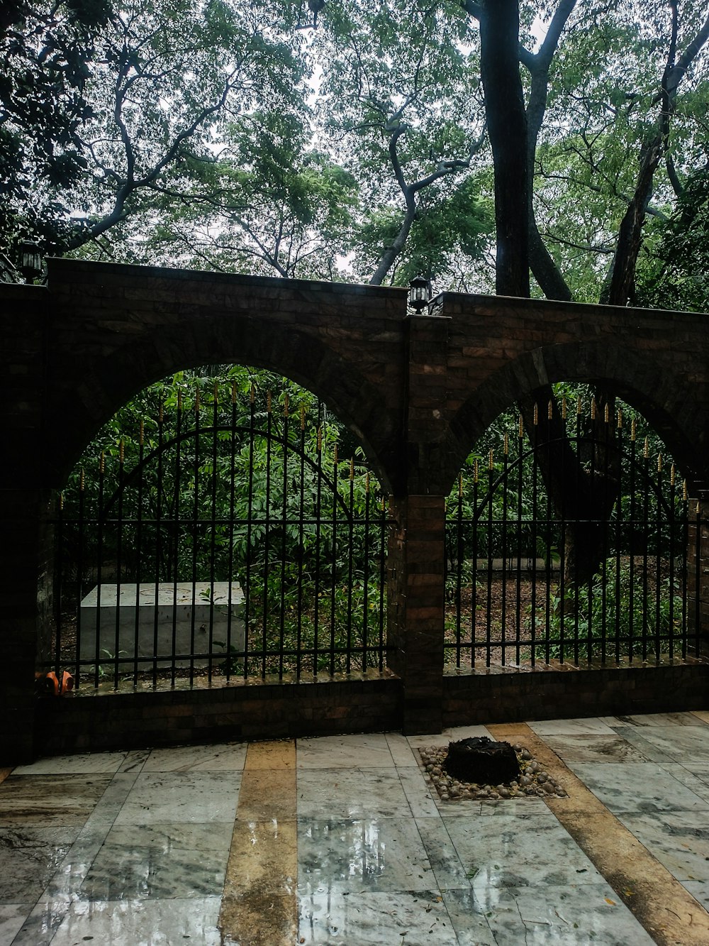 a stone floor with a fence and trees in the background