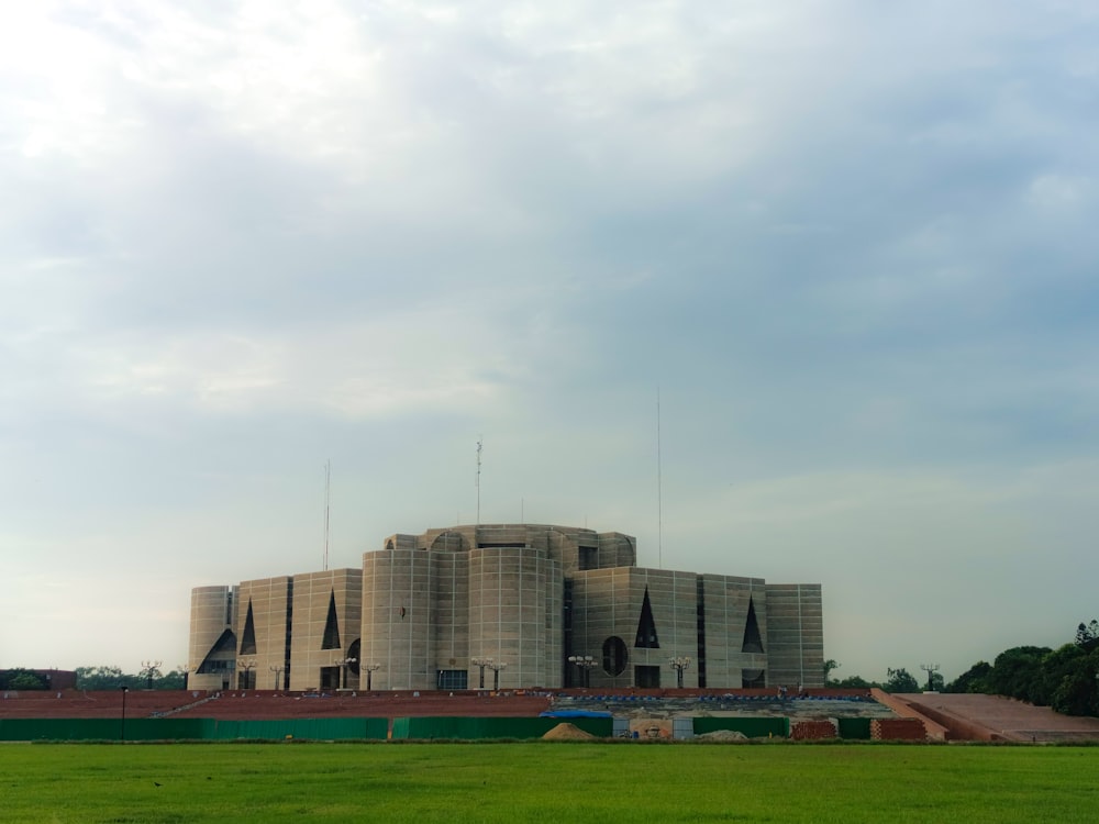 a large building sitting on top of a lush green field