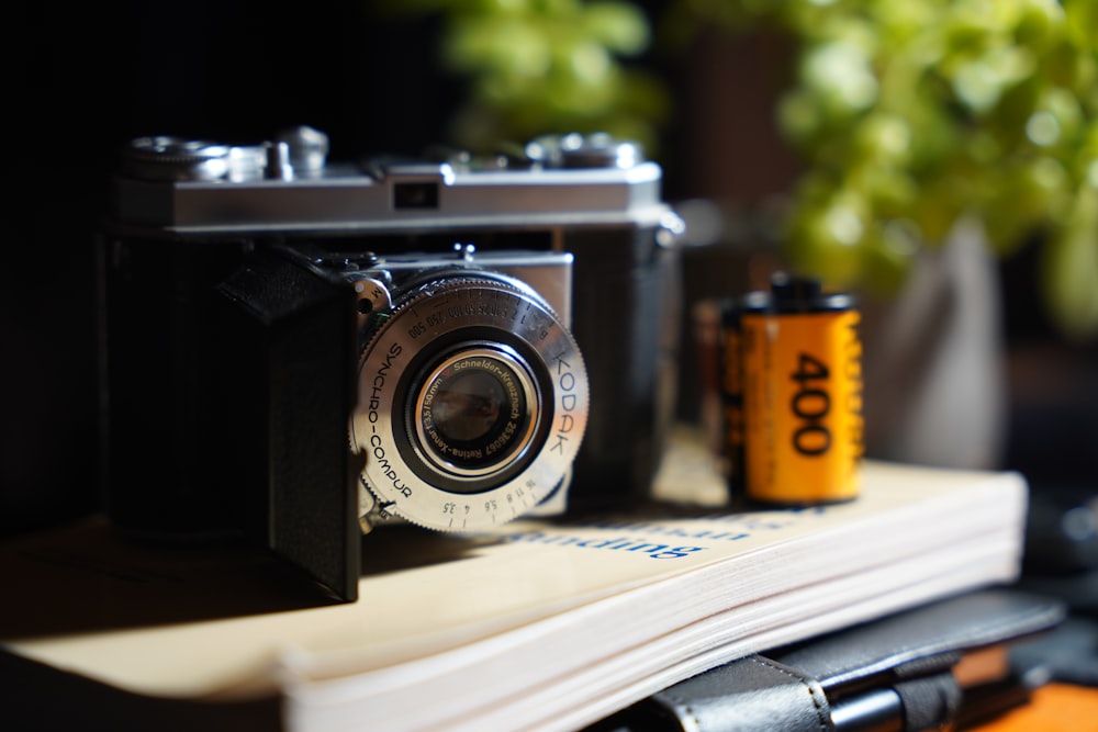 a camera sitting on top of a book next to a plant