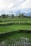 A scenic view of lush green rice terraces in Ubud under a clear blue sky.