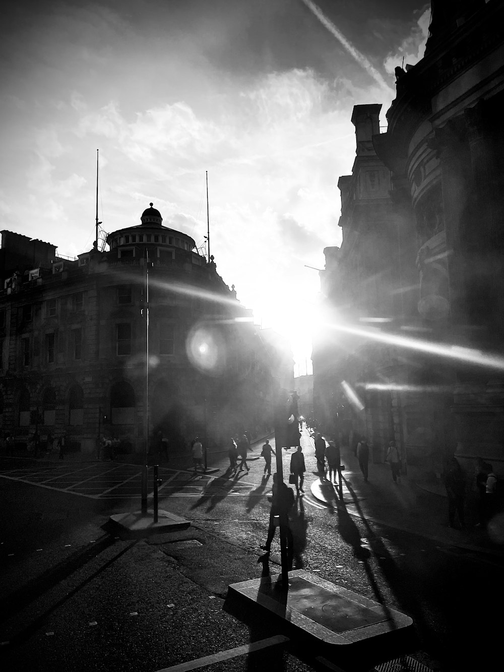 a black and white photo of people walking down a street