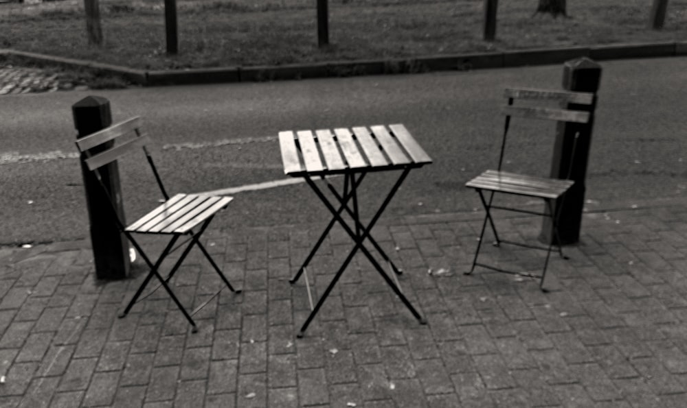 a couple of chairs and a table on a sidewalk
