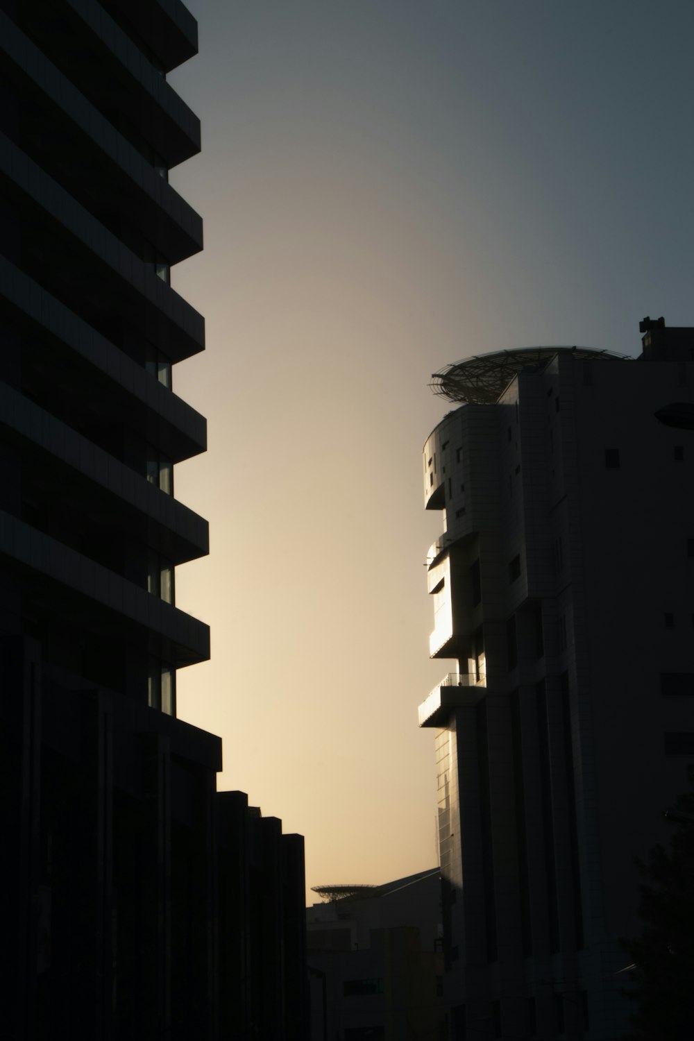 the sun is setting behind some tall buildings