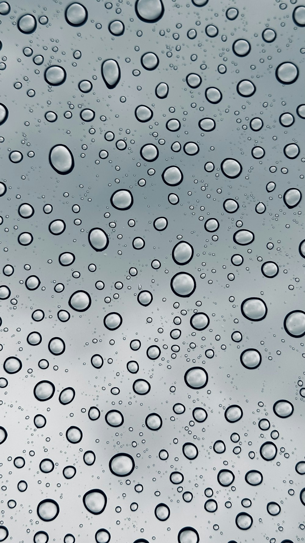 rain drops on a window with a sky background