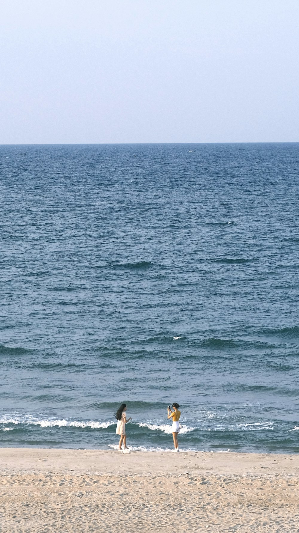 Un couple de personnes debout au sommet d’une plage de sable