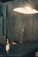 A modern pendant light hanging above a stylish dining table set for an intimate dinner.