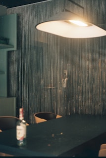 A modern pendant light hanging above a stylish dining table set for an intimate dinner.