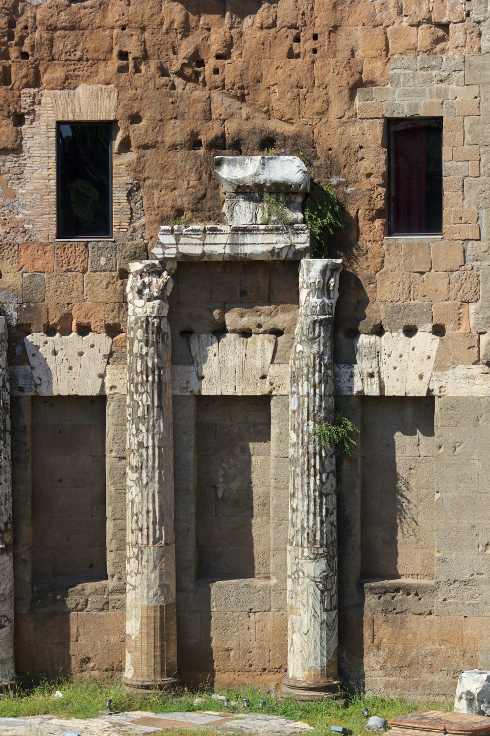 an old building with two stone pillars and two windows