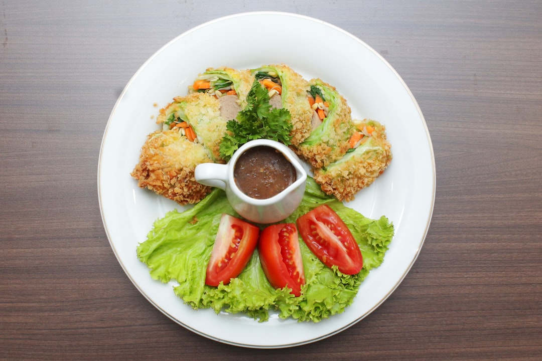 a white plate topped with food on top of a wooden table,