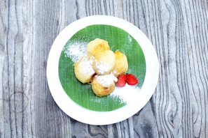 Delicate fried raisin slices (pasas fritas) displayed on a natural leaf plate.