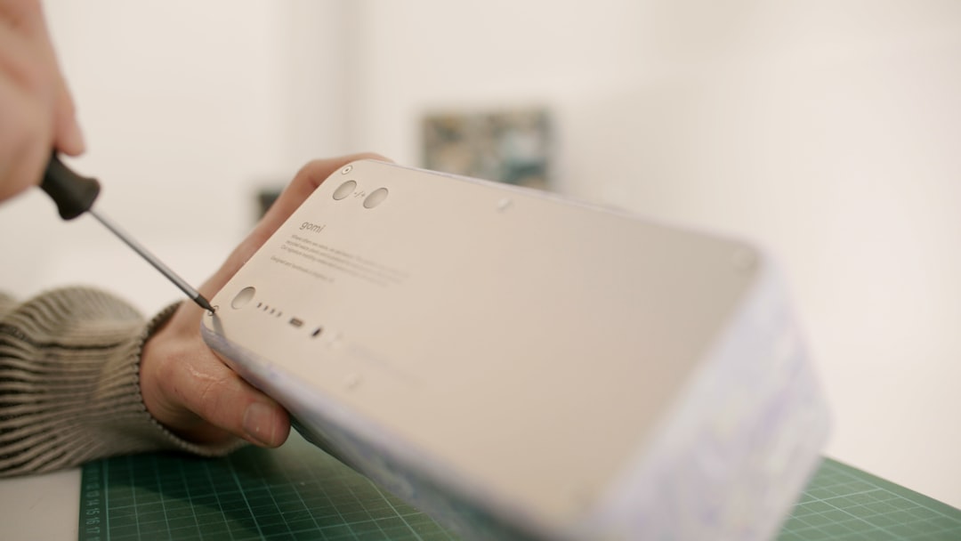 a person cutting a piece of paper with a pair of scissors, gomi Speaker Assembly