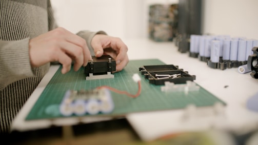 Close-up of hands assembling components on a workshop table.