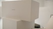 Stacked white boxes with minimalistic design featuring a label 'COLLECTION 1'. The setting appears to be clean and well-organized, possibly in a storage or retail environment.
