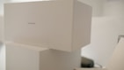 Stacked white boxes with minimalistic design featuring a label 'COLLECTION 1'. The setting appears to be clean and well-organized, possibly in a storage or retail environment.
