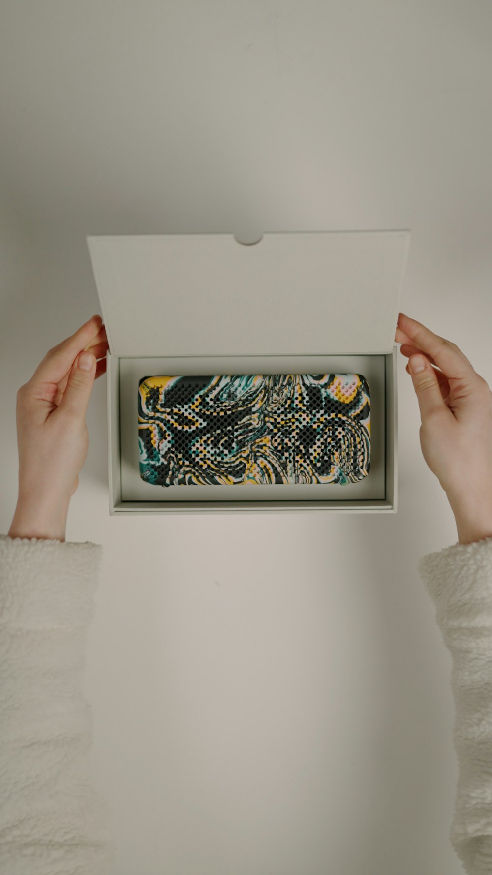 a person holding a box with a painting inside of it
