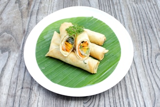 A colorful platter of assorted spring rolls filled with chicken, cheese, and vegetables.