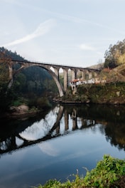 a bridge over a river with a building in the background