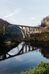 a bridge over a river with a building in the background