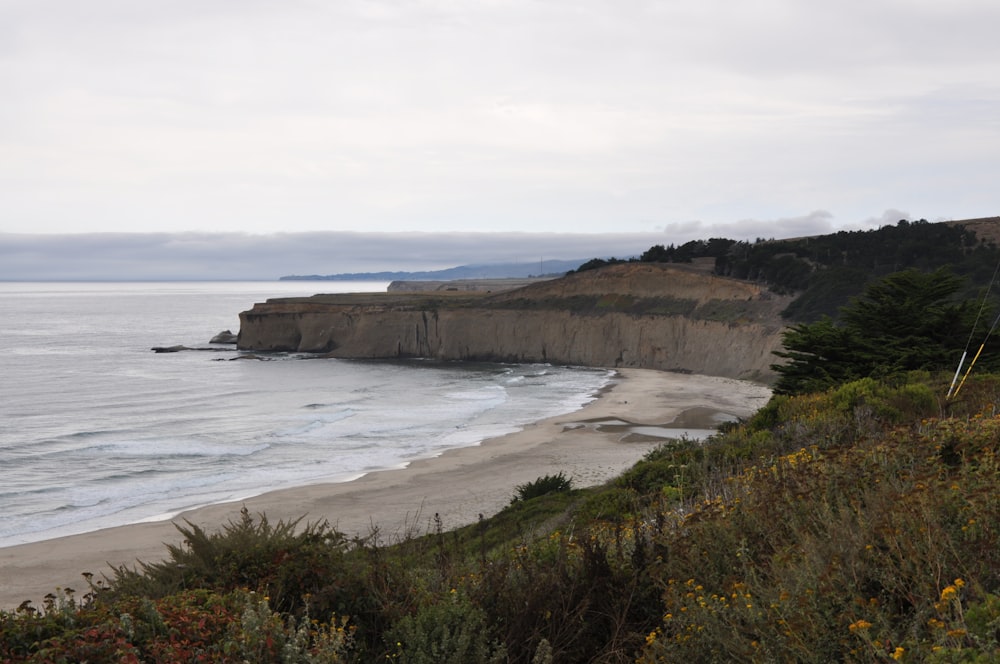 a view of a beach with a cliff in the background