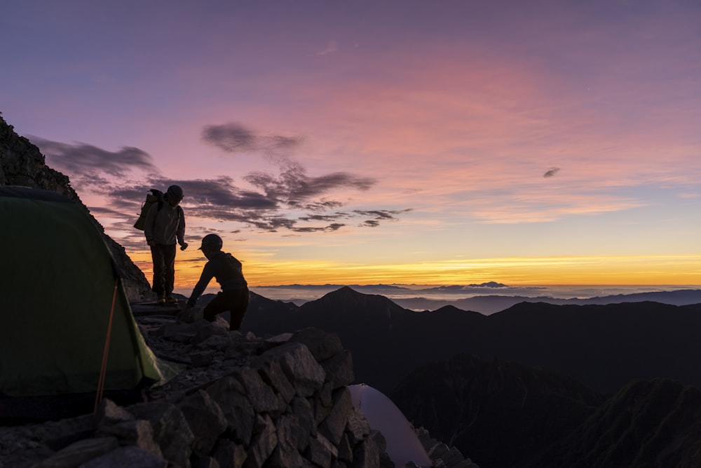 a couple of people standing on top of a mountain