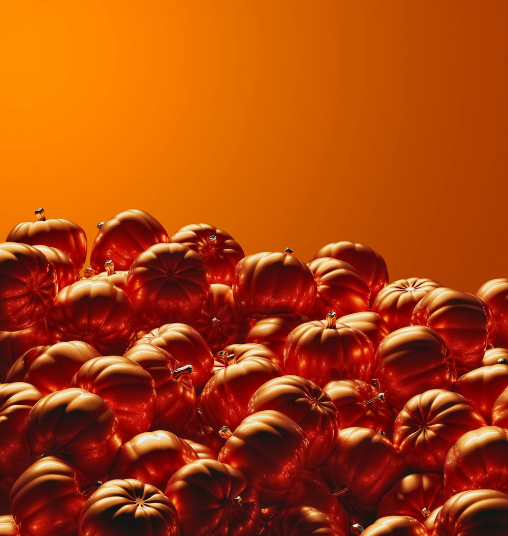 a large group of orange pumpkins sitting on top of each other