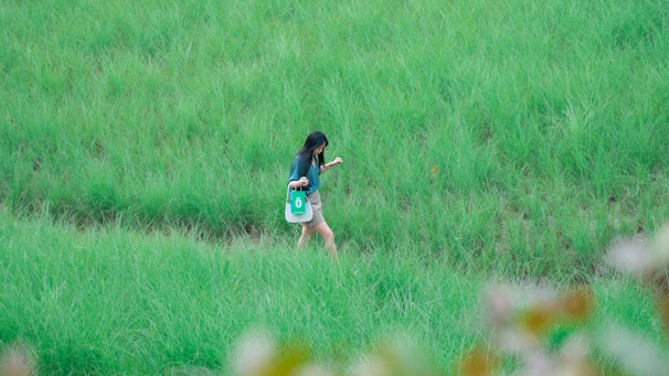 A person carrying an eco-friendly jute bag while walking through a green park.