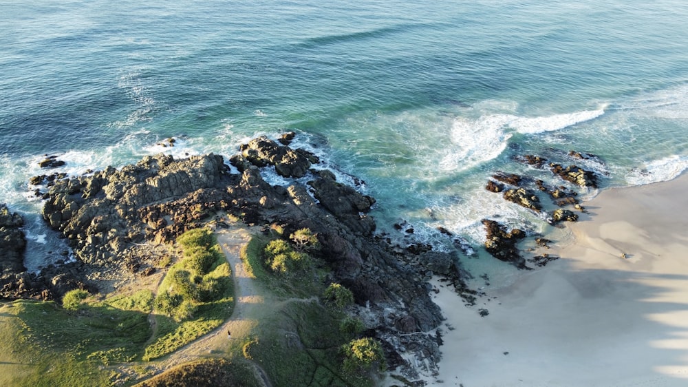 an aerial view of a rocky beach and ocean