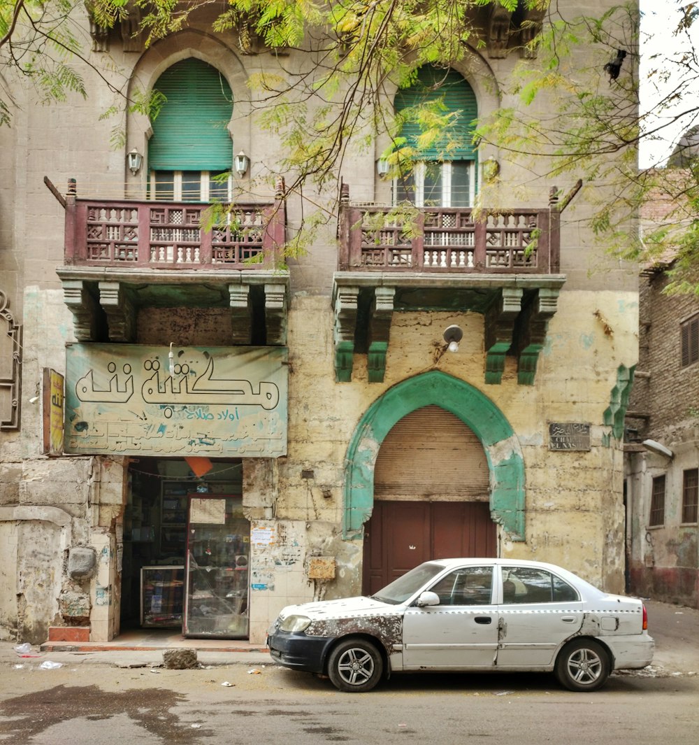 a white car parked in front of a building