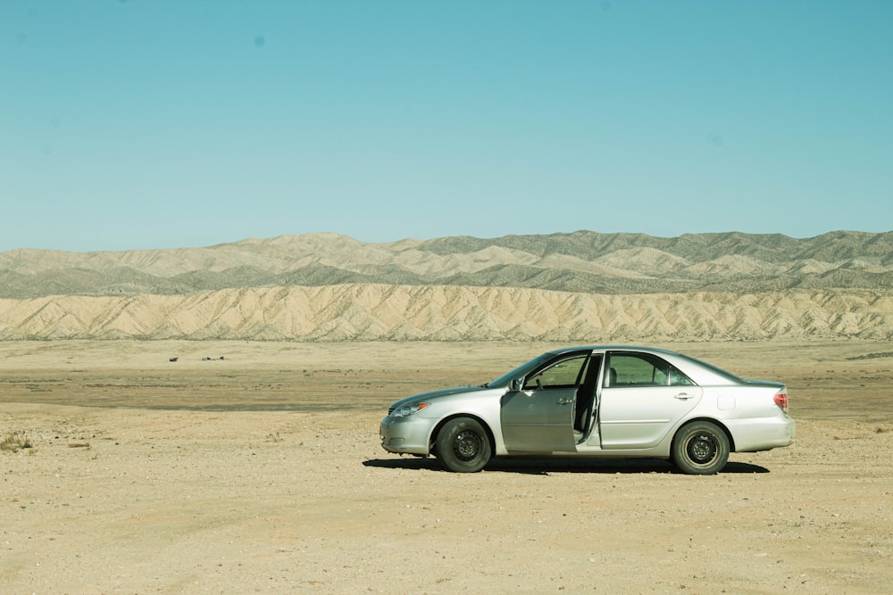 a small car parked in the middle of a desert