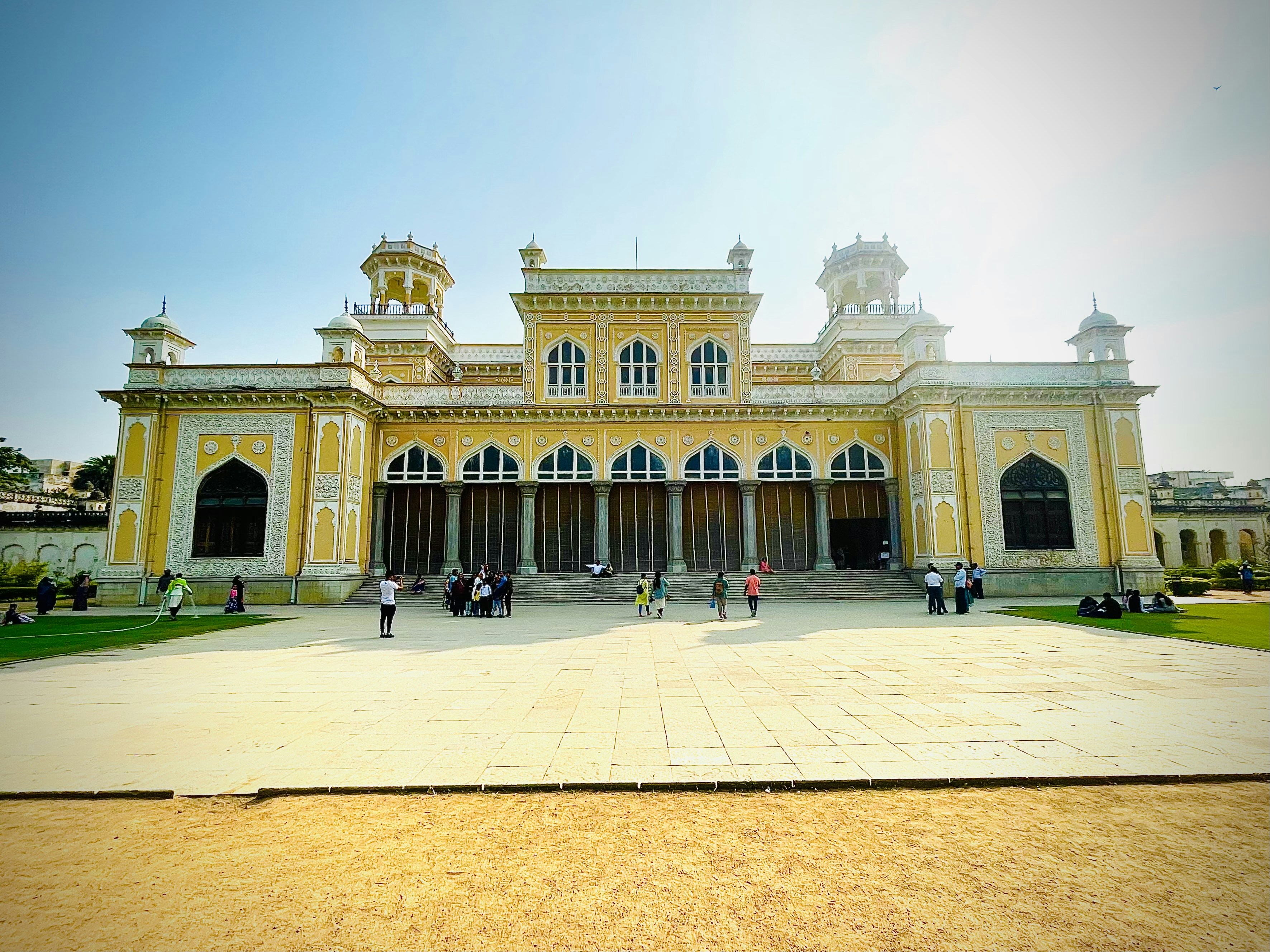 a yellow and white building with people standing outside