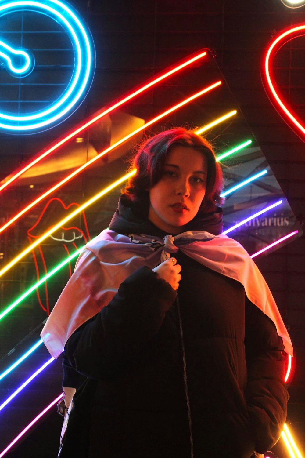 a woman standing in front of a neon sign