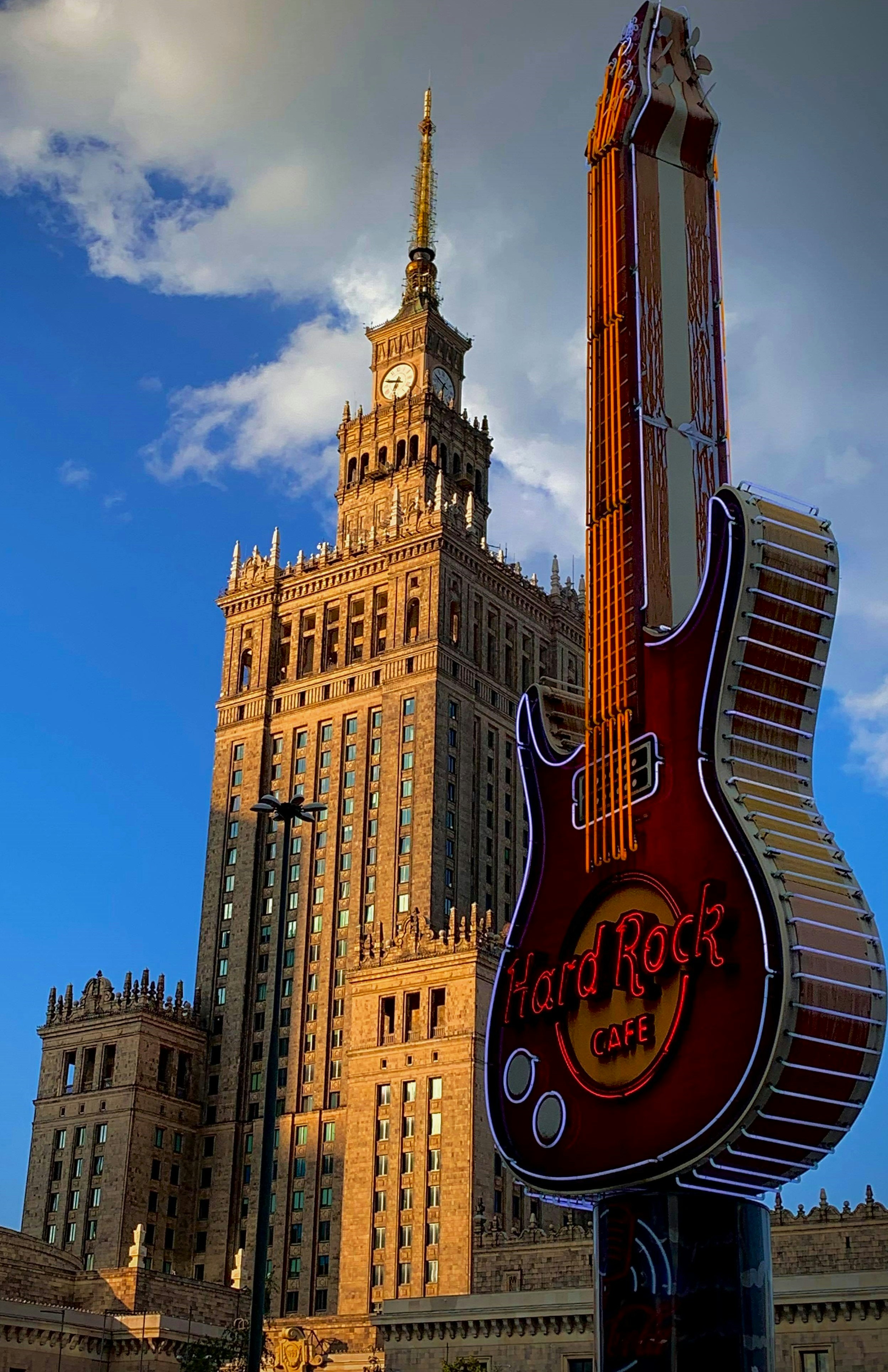 Ein gitarrenförmiges Schild vor einem hohen Gebäude