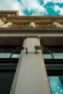Wide angle view of a building facade equipped with multiple surveillance cameras.