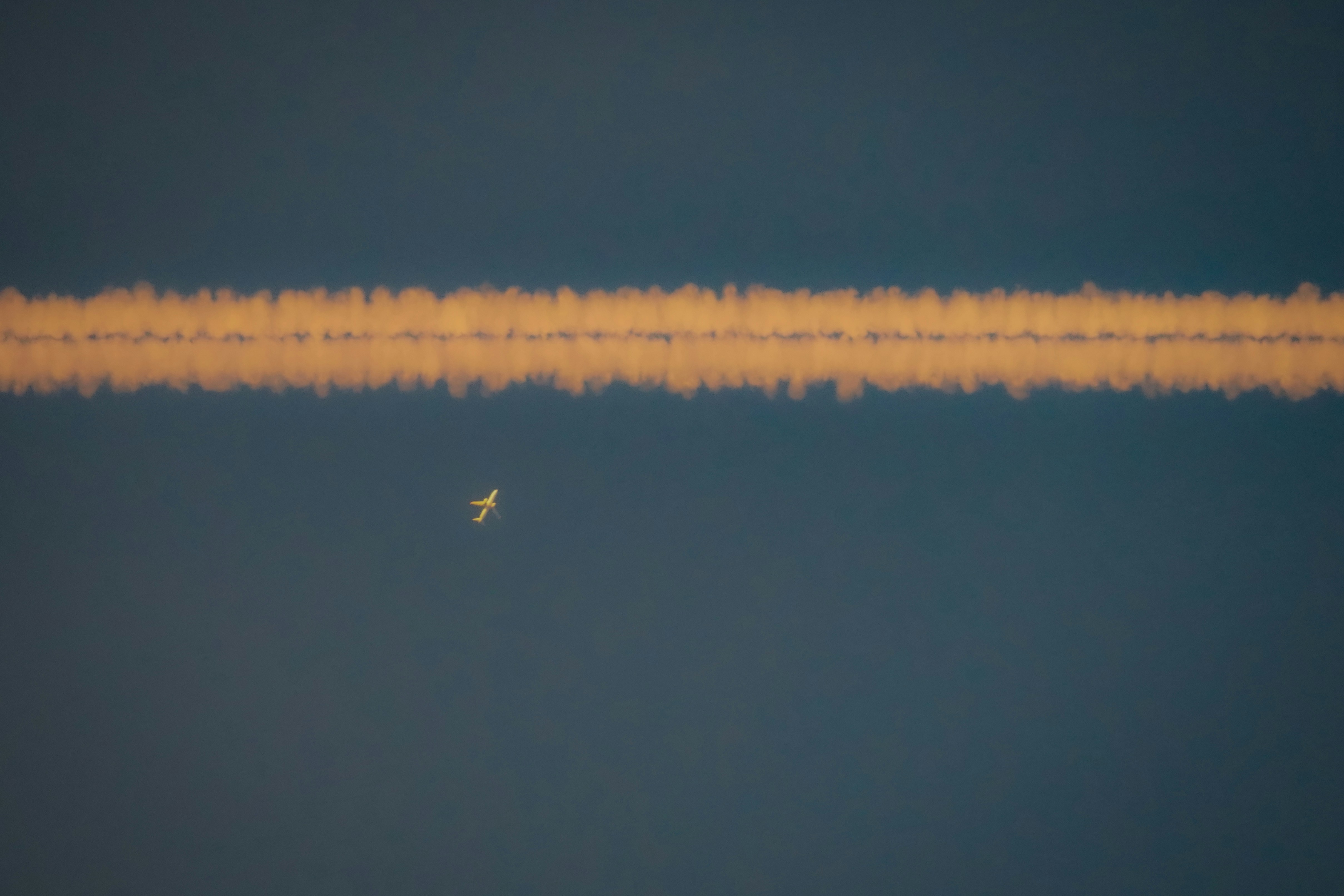 Foto Un avión está volando en el cielo con una larga franja de humo ...