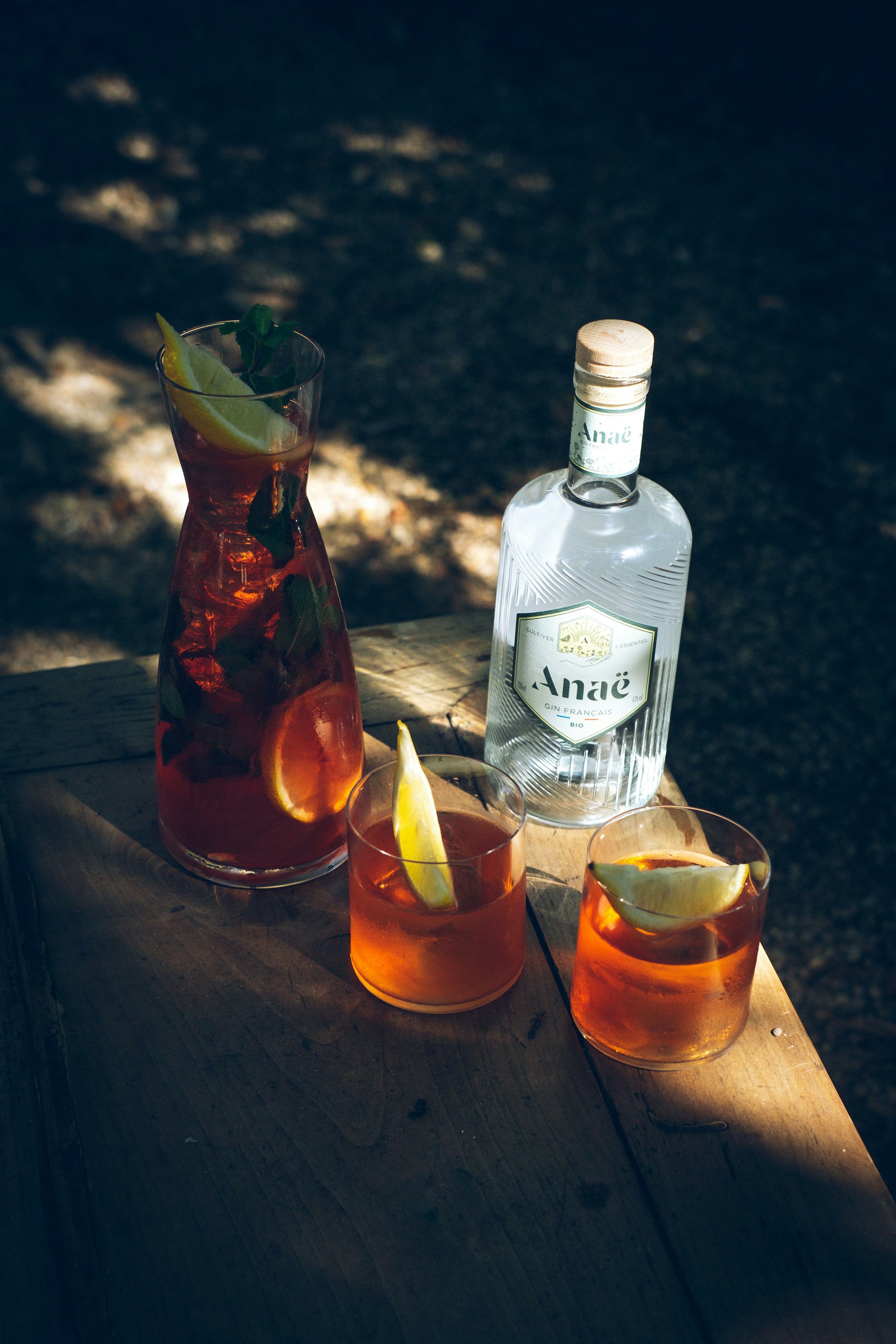 a wooden table topped with two glasses filled with drinks
