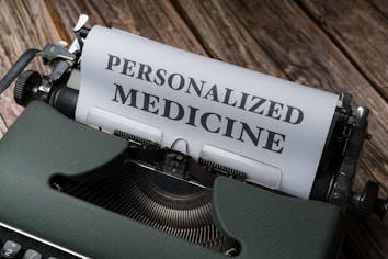 A vintage typewriter with a sheet of paper that has the words 'PERSONALIZED MEDICINE' typed in bold letters. The typewriter is placed on a rustic wooden surface, giving a classic and nostalgic feel.