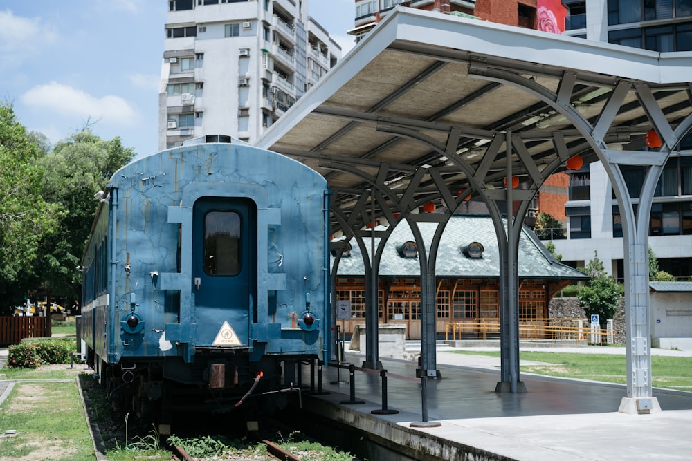 a blue train parked at a train station