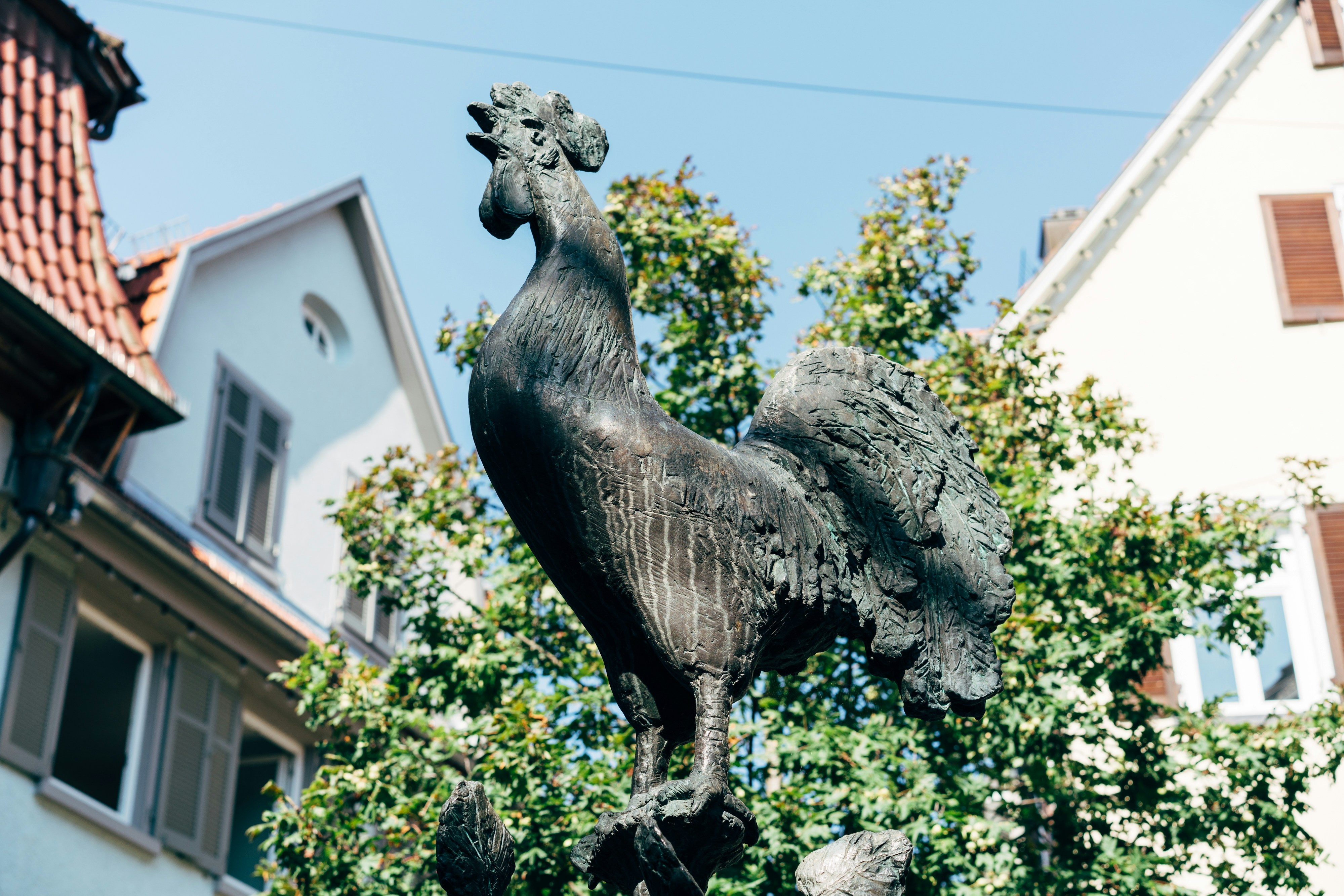 a statue of a rooster on top of a pole