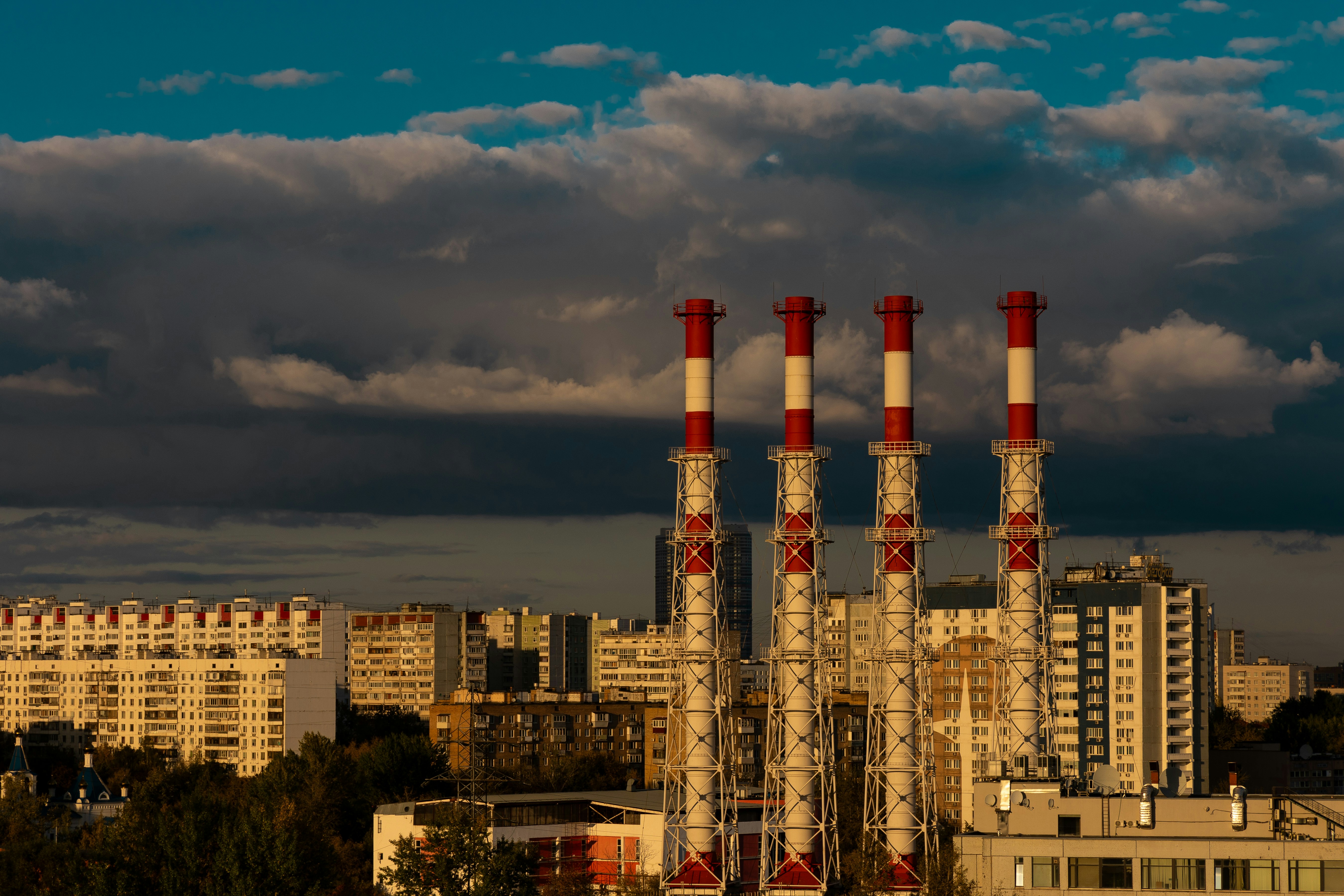 a factory with red and white smoke stacks