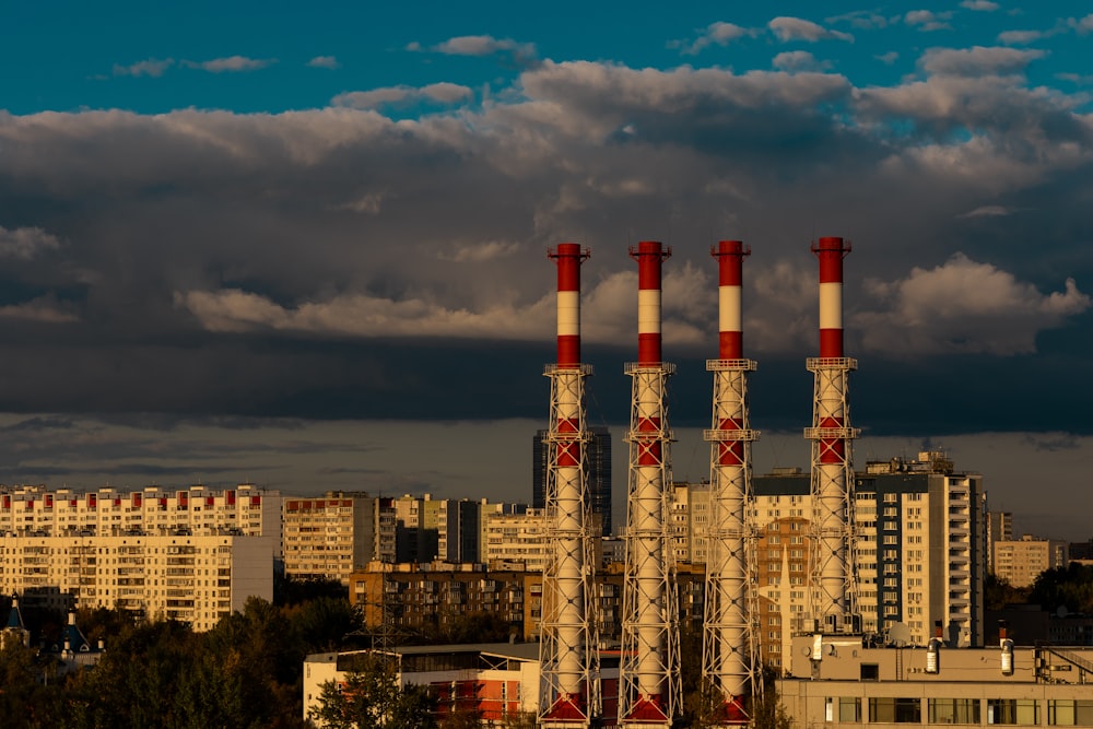 a factory with red and white smoke stacks