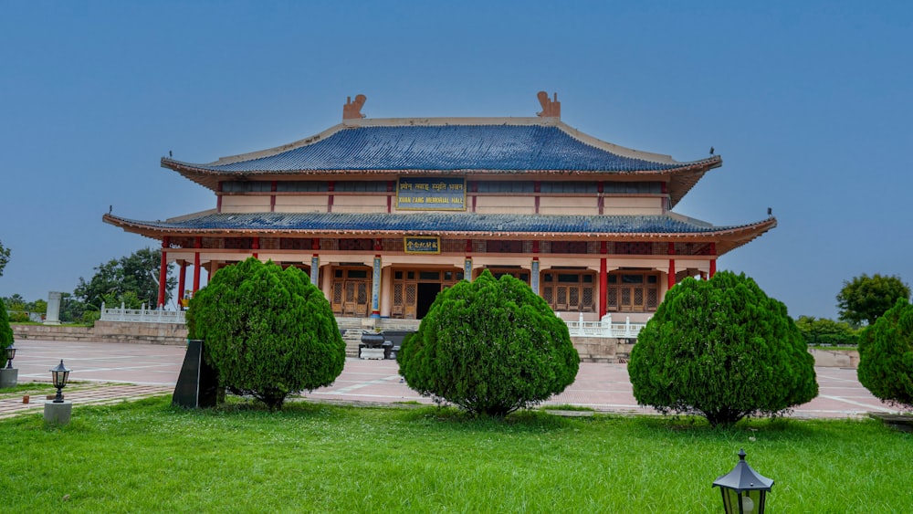 a tall building with a blue roof surrounded by trees