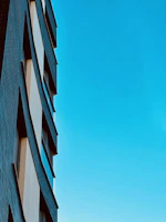 A sleek modern hospital building exterior with clear blue sky background.