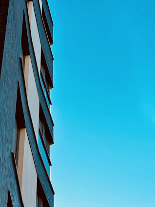 A sleek modern building under construction bathed in warm sunlight, showcasing clean lines and cobalt blue accents.