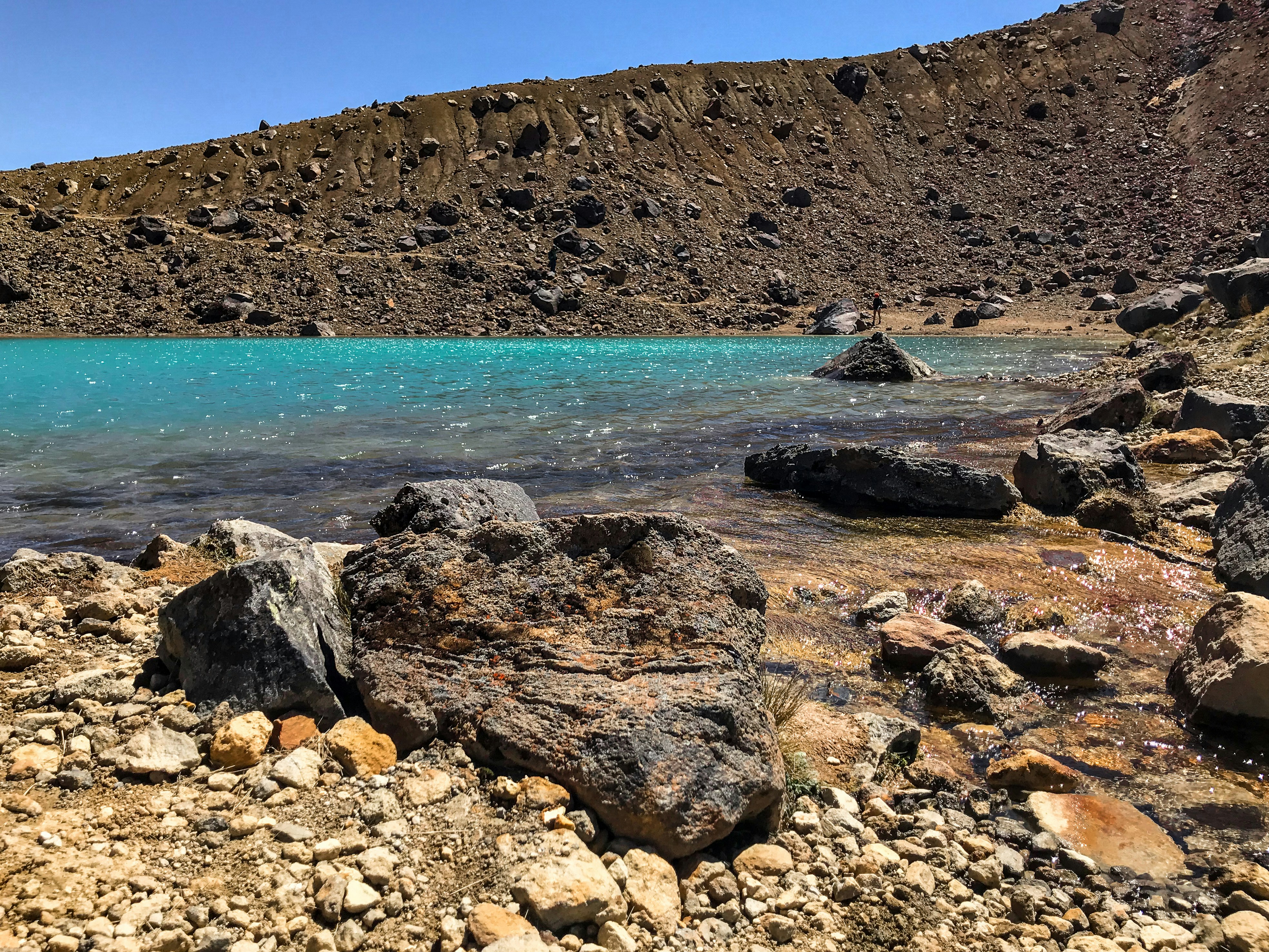 a body of water surrounded by rocks and a mountain, 