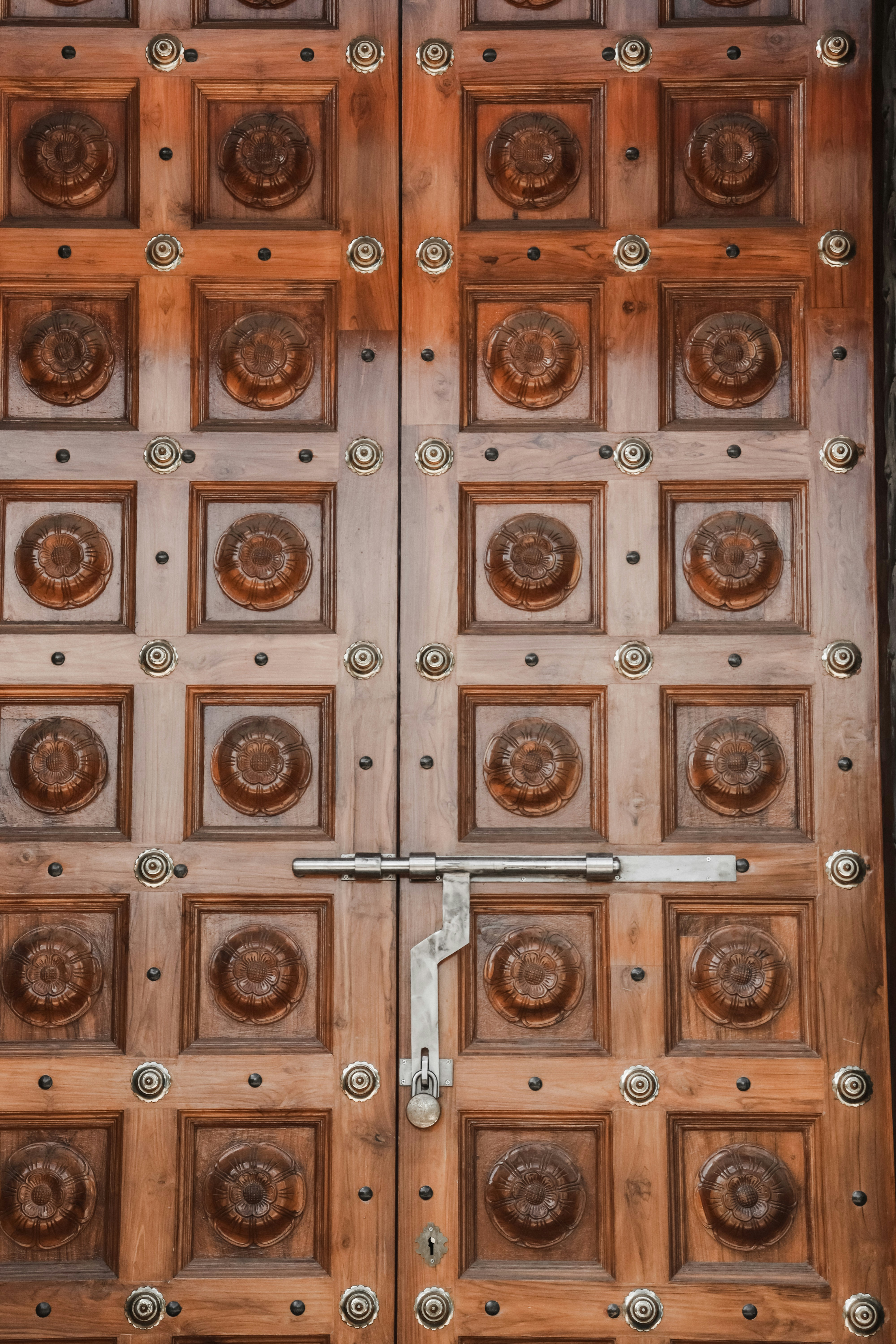 a close up of a wooden door with metal handles